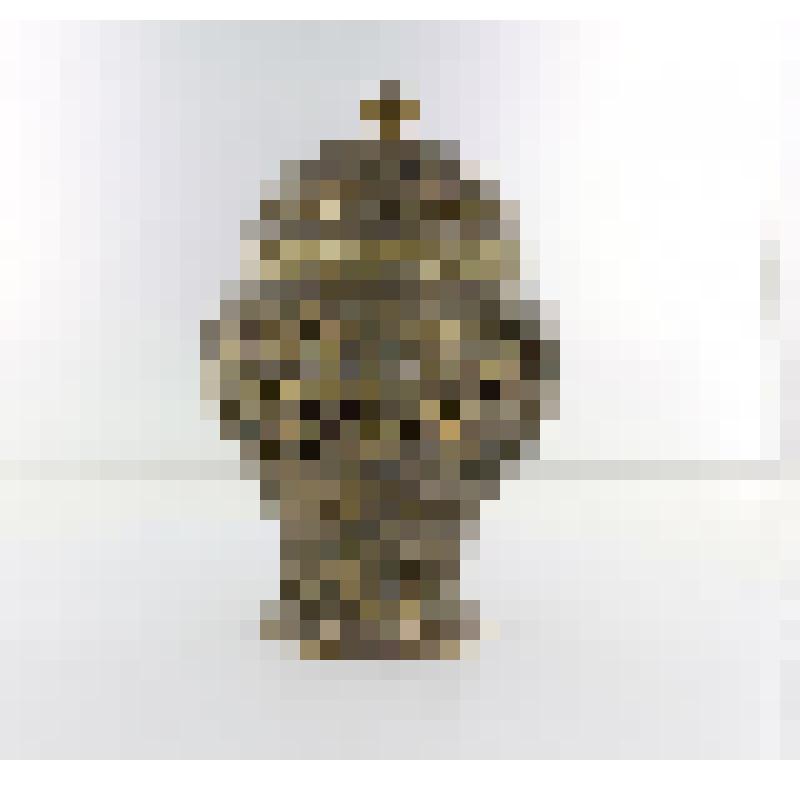 Вазочка с округлым туловом, плавно переходящая в цилиндрический поддон, слегка расширяющийся в нижней части. Украшена прорезным орнаментом растительного характера и стилизованным изображением людей. Полусферическая крышка,оканчивающаяся грибком также укра